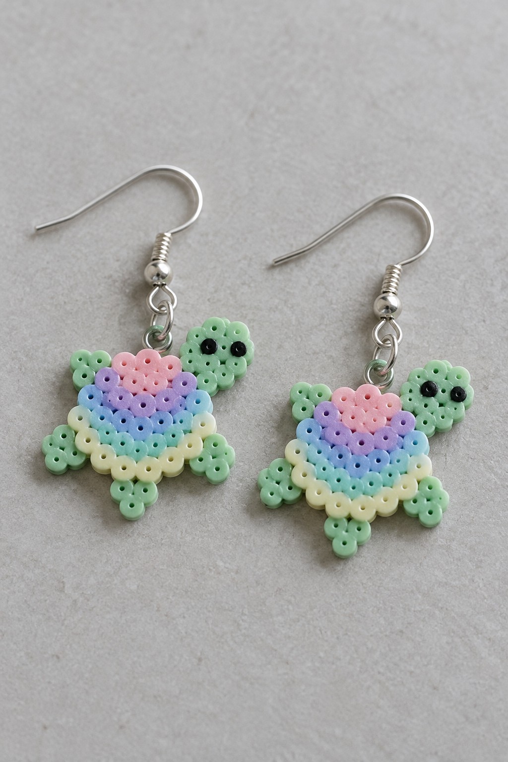 Two pastel rainbow perler bead turtle earrings with silver hooks