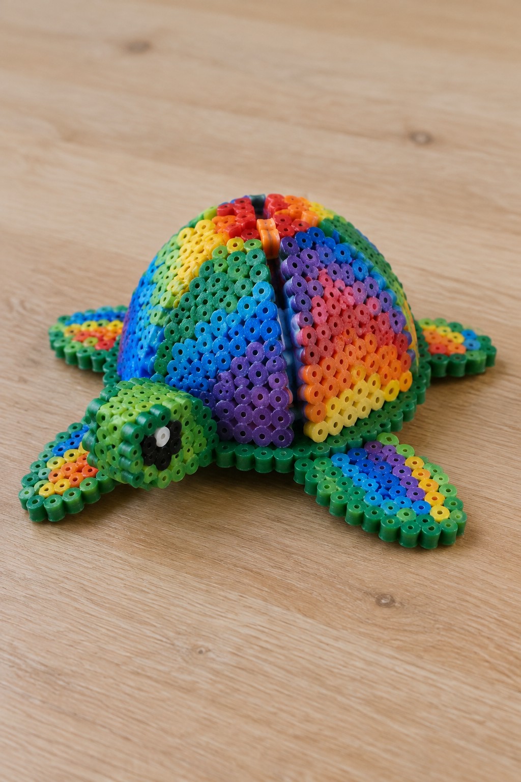 Rainbow Perler bead turtle with green head and colorful shell on wood