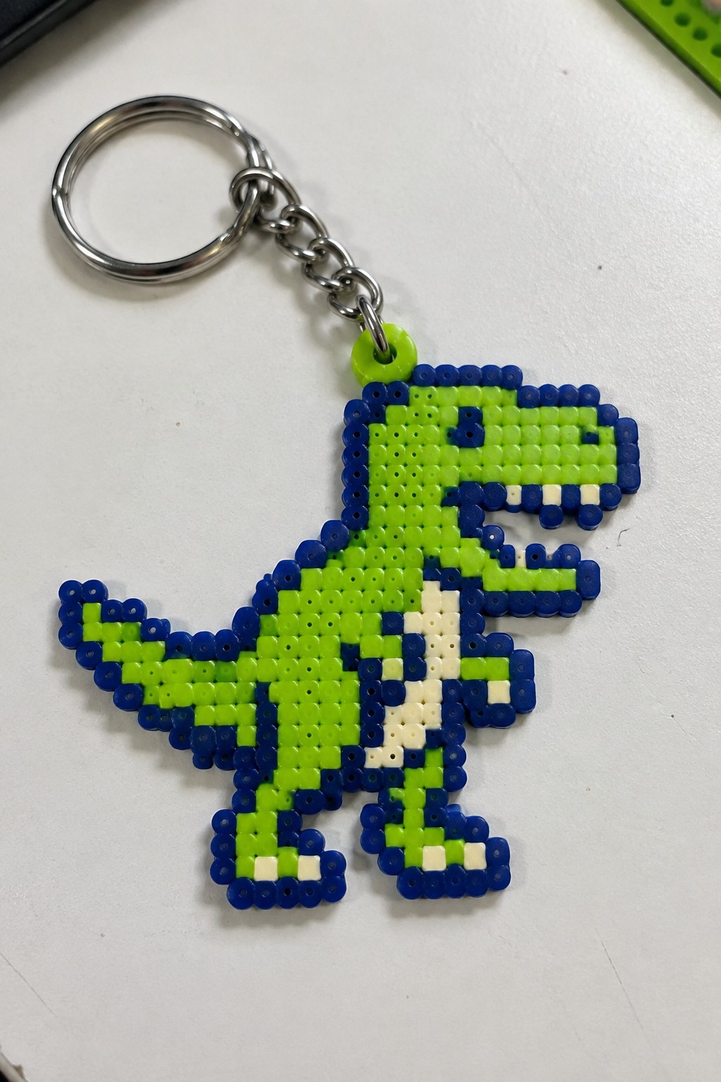 Green and blue perler bead T-Rex dinosaur keychain with silver ring and chain