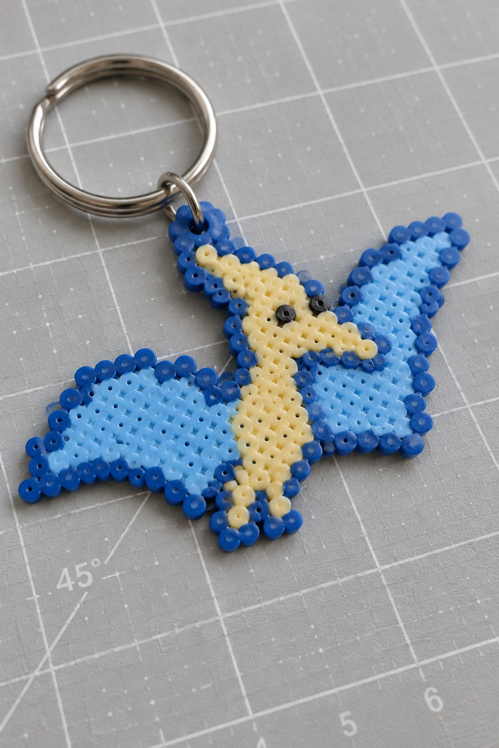 Blue and yellow perler bead butterfly keychain on silver metal ring