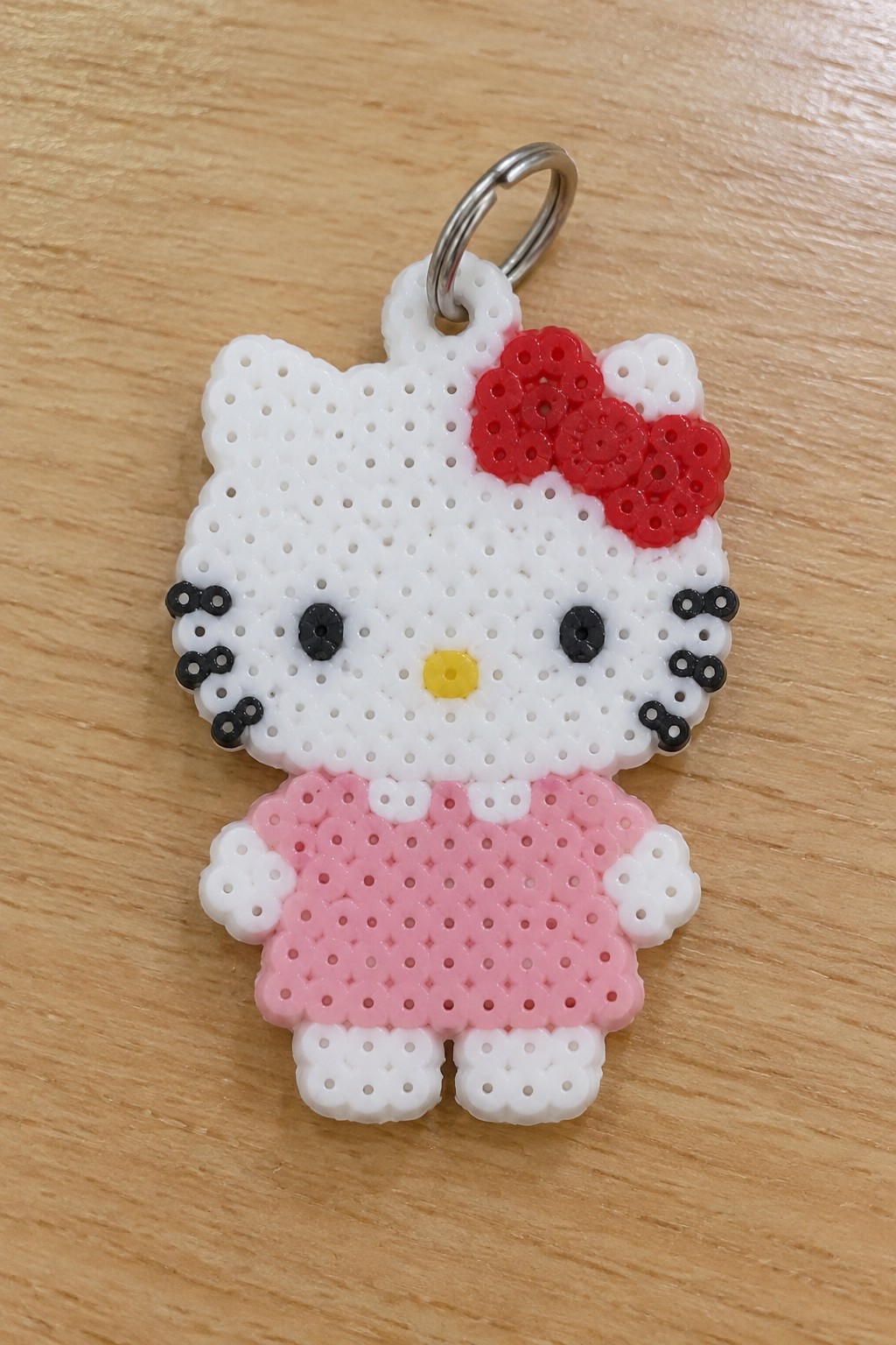 Hello Kitty perler bead keychain with red bow, pink dress, metal ring