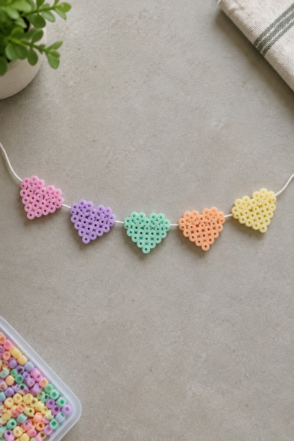 Pastel perler bead hearts in pink, purple, mint, peach and yellow on string