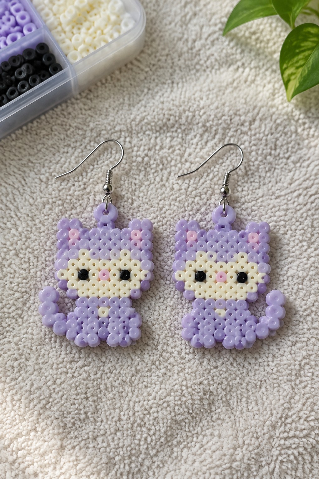 Purple and white beaded cat earrings with black eyes on silver hooks
