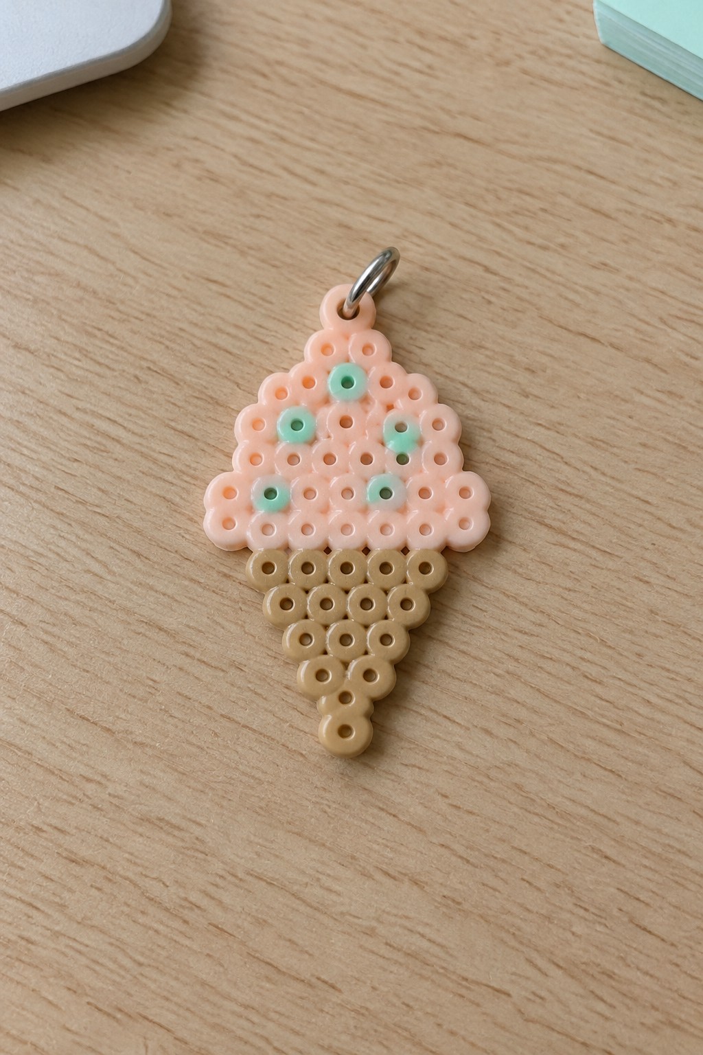 Perler bead ice cream cone charm with pink scoops, mint dots, and brown cone