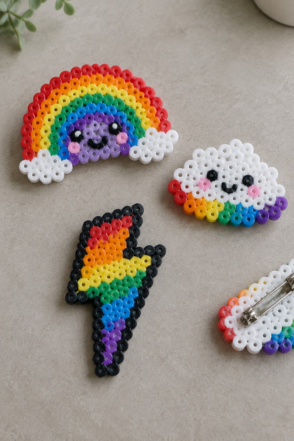 Colorful perler bead rainbow, smiling cloud, and lightning bolt crafts with faces.