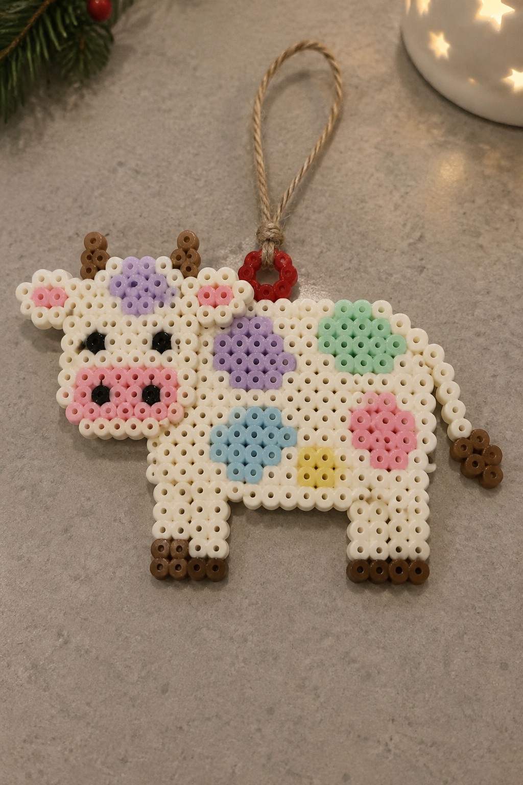 Colorful perler bead cow ornament with pastel spots and hanging twine