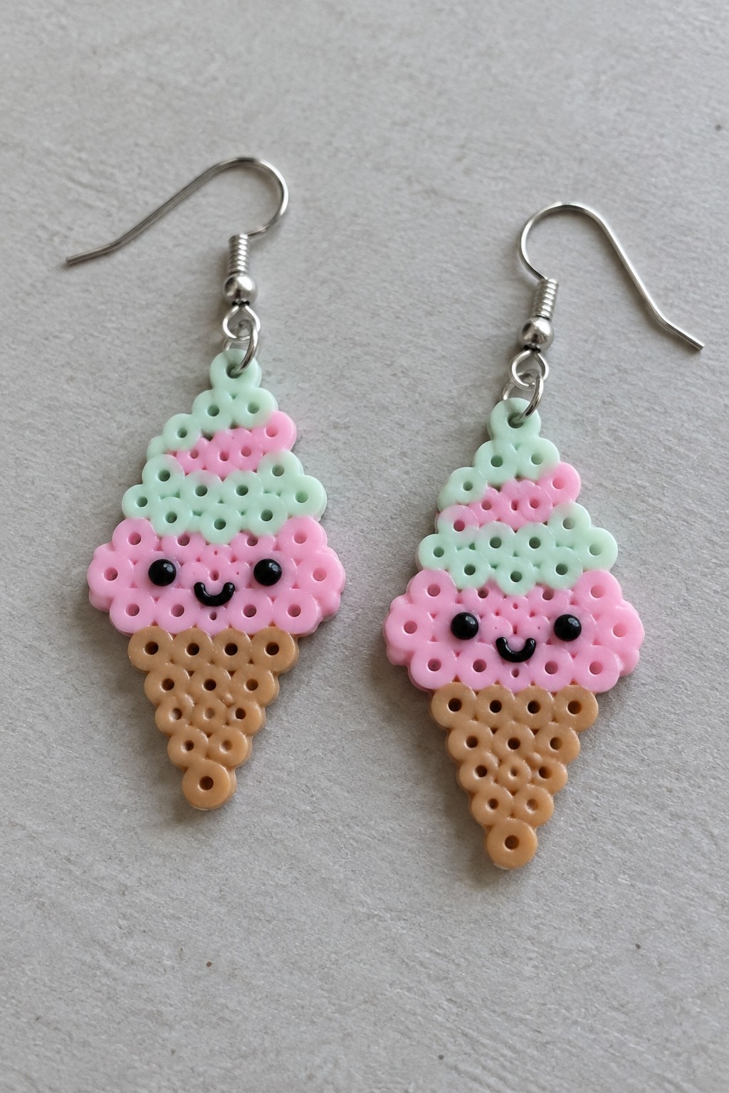 Pair of perler bead ice cream cone earrings with pink scoops and smiling faces