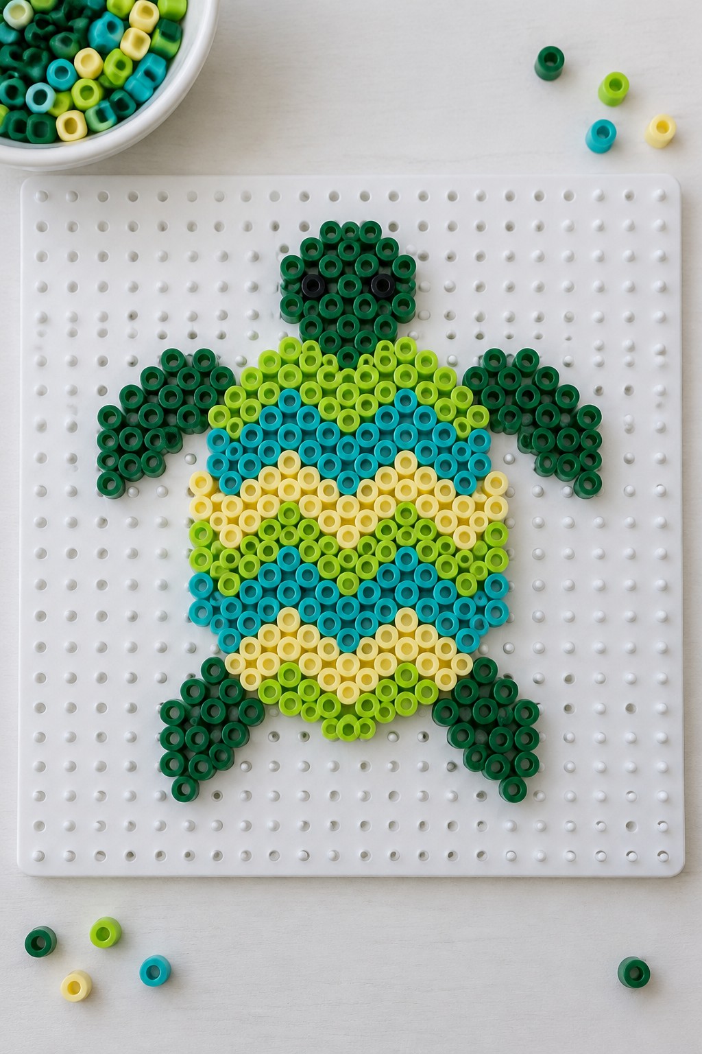 Perler bead turtle with green head and colorful shell on white pegboard