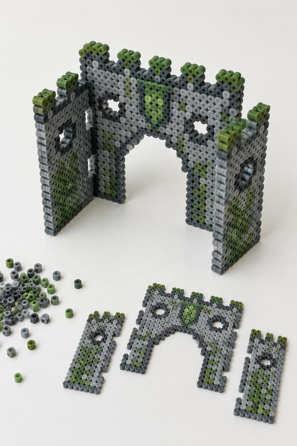 Green and gray perler bead ruins with arches, towers, and scattered loose beads