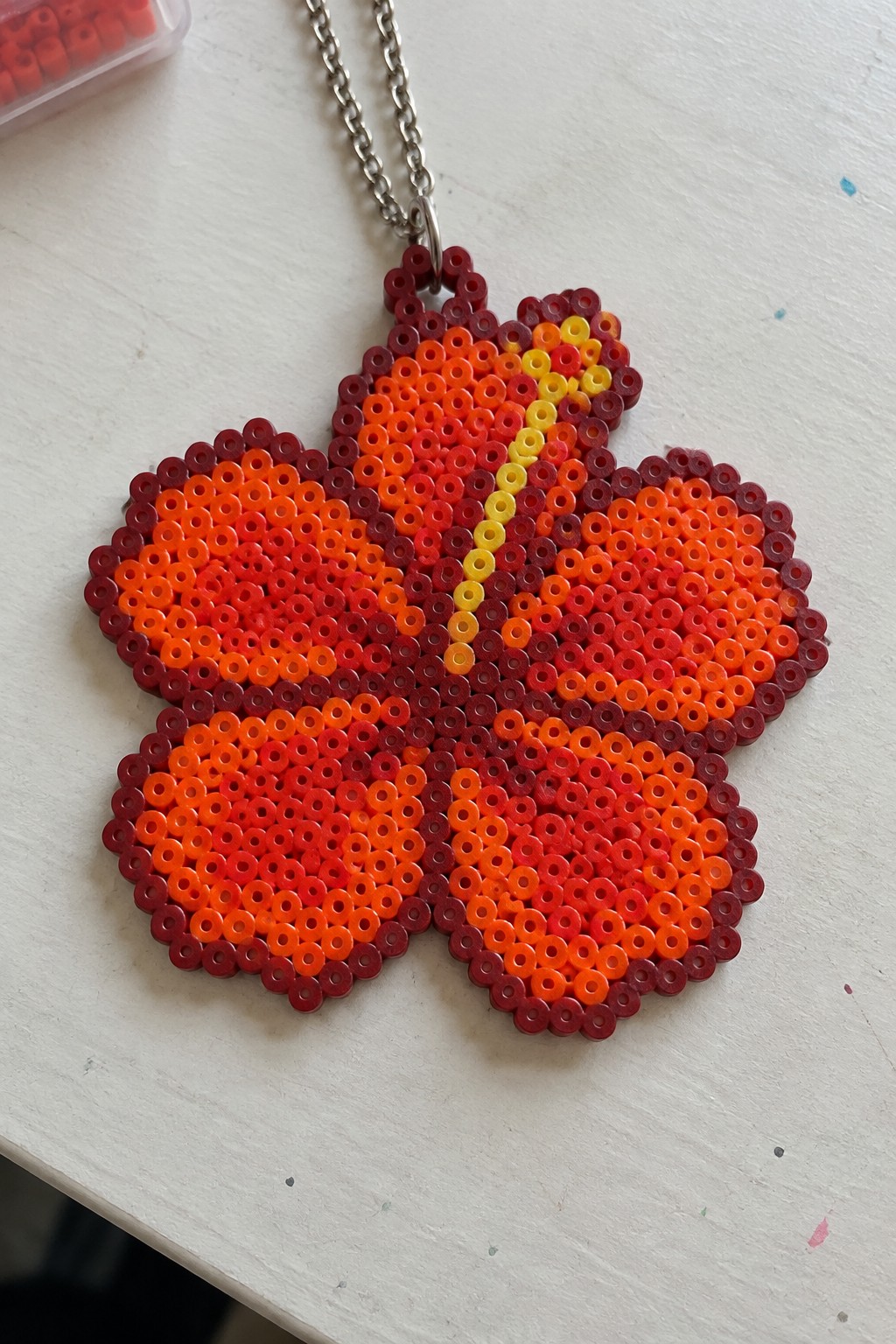 Perler bead flower pendant necklace with red-orange-yellow gradient on silver chain