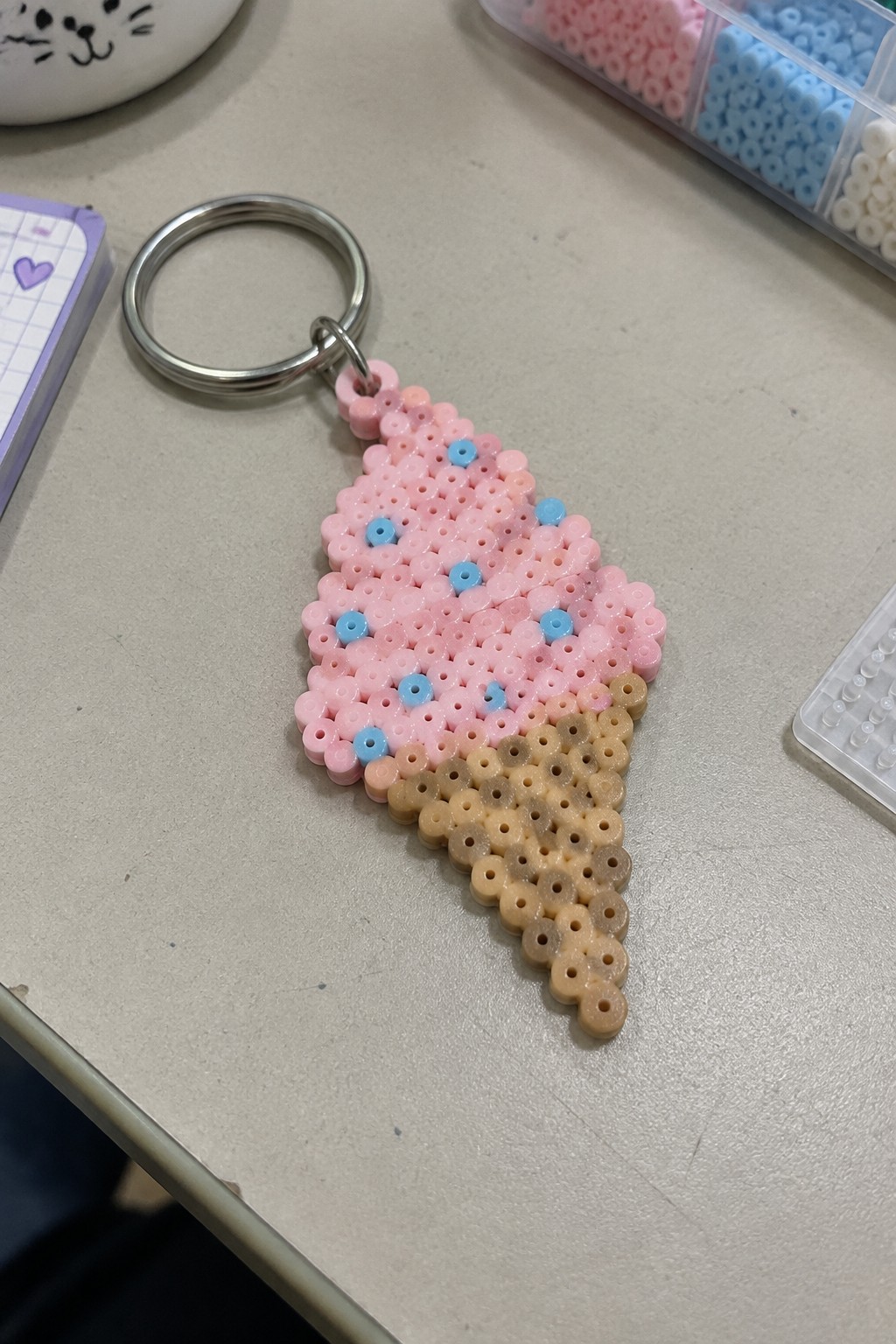 Perler bead ice cream cone keychain with pink scoop, blue dots, and tan cone