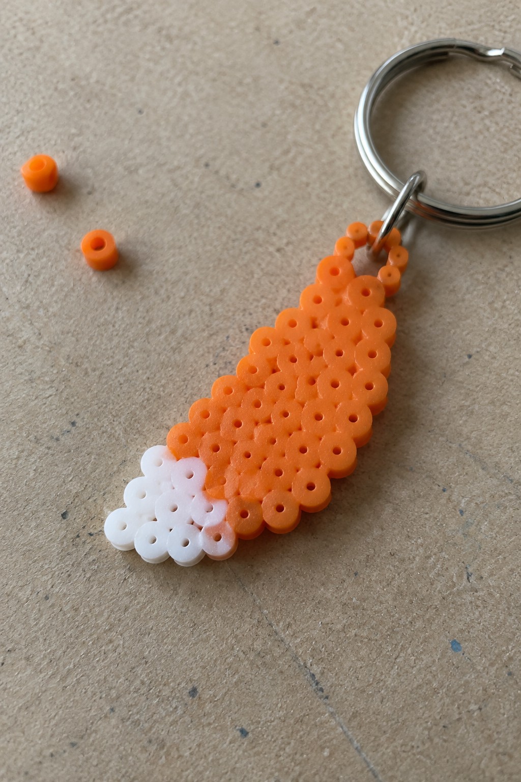 Orange and white perler bead carrot keychain with metal ring and loose beads