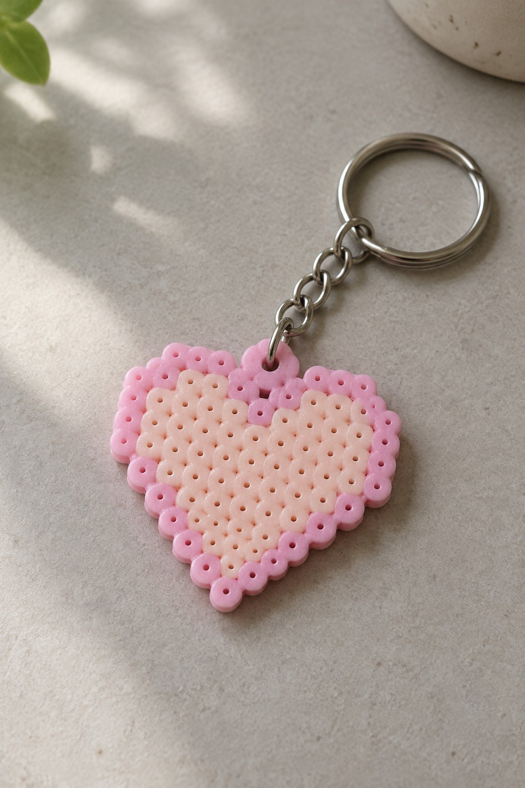 Fused Perler bead heart keychain in two shades of pink attached to a metal keyring.