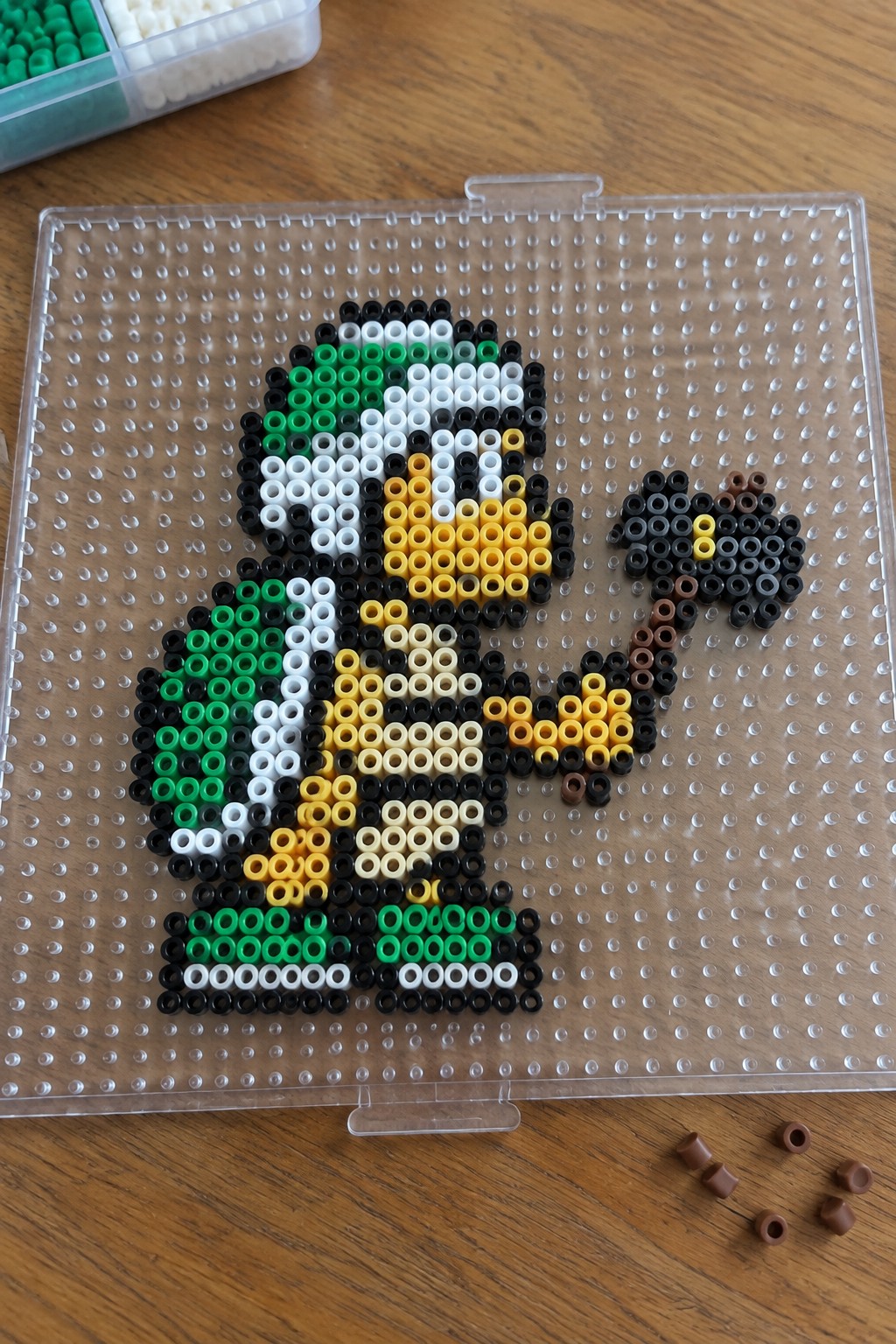 Perler bead pixel art of helmeted figure with rifle on pegboard